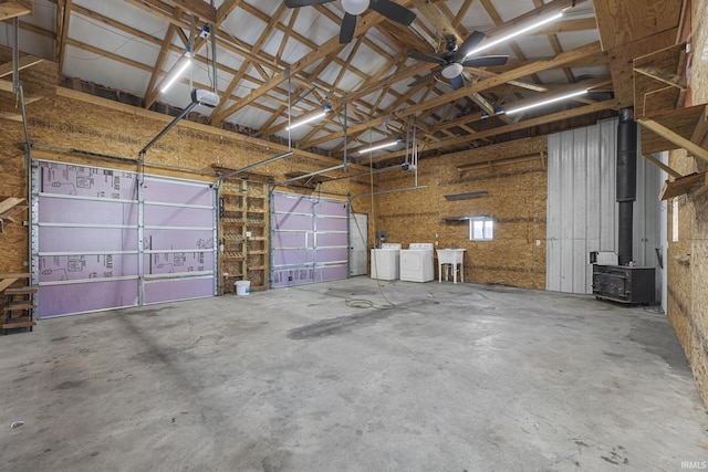 garage featuring a sink, a wood stove, and a ceiling fan