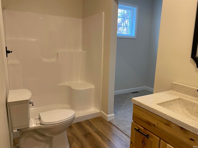 bathroom with wood-type flooring, vanity, and toilet