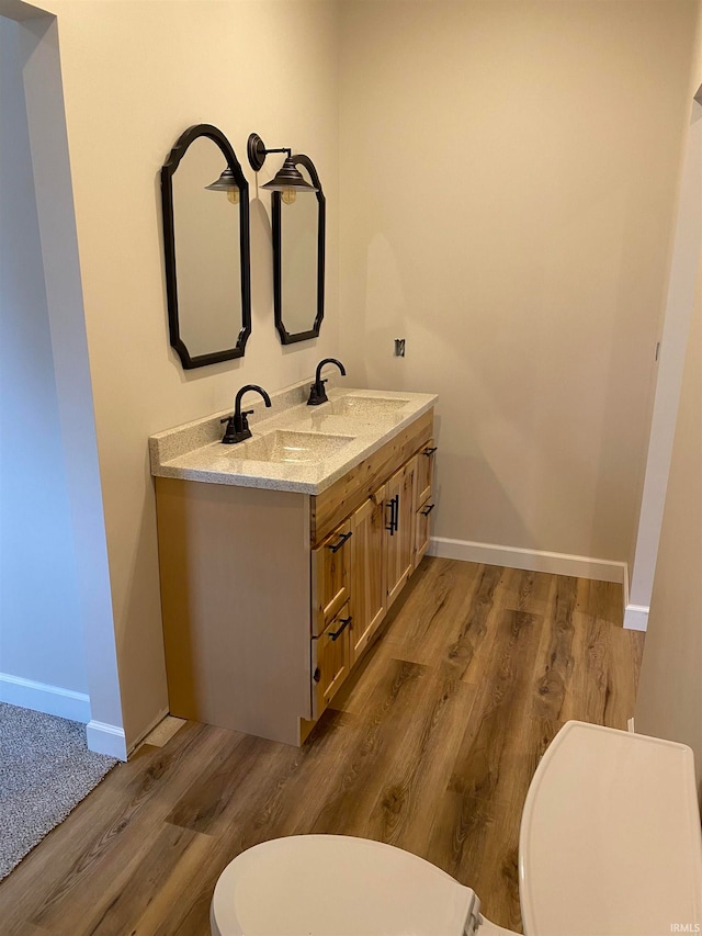 bathroom featuring hardwood / wood-style floors, vanity, and toilet