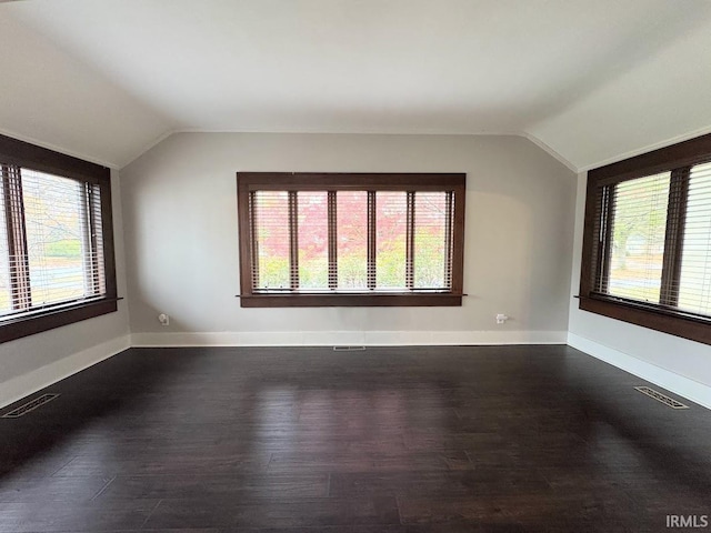 bonus room with visible vents, lofted ceiling, and dark wood-style flooring