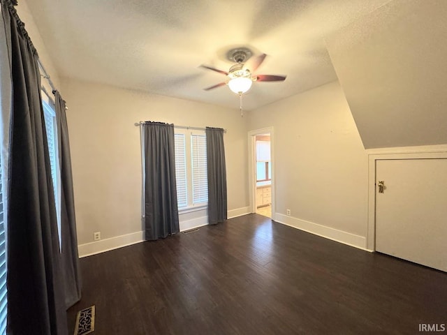 unfurnished room featuring dark wood finished floors, ceiling fan, a textured ceiling, and baseboards