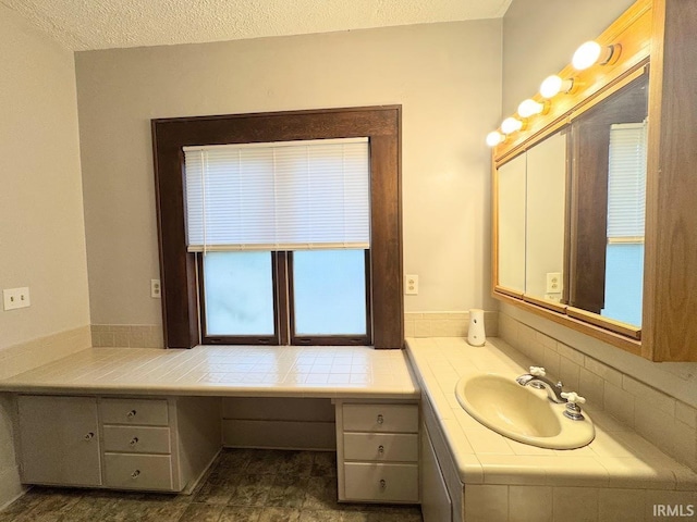 bathroom with a textured ceiling and vanity