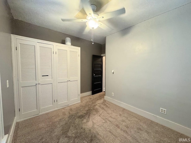 unfurnished bedroom featuring a closet, ceiling fan, baseboards, and carpet floors