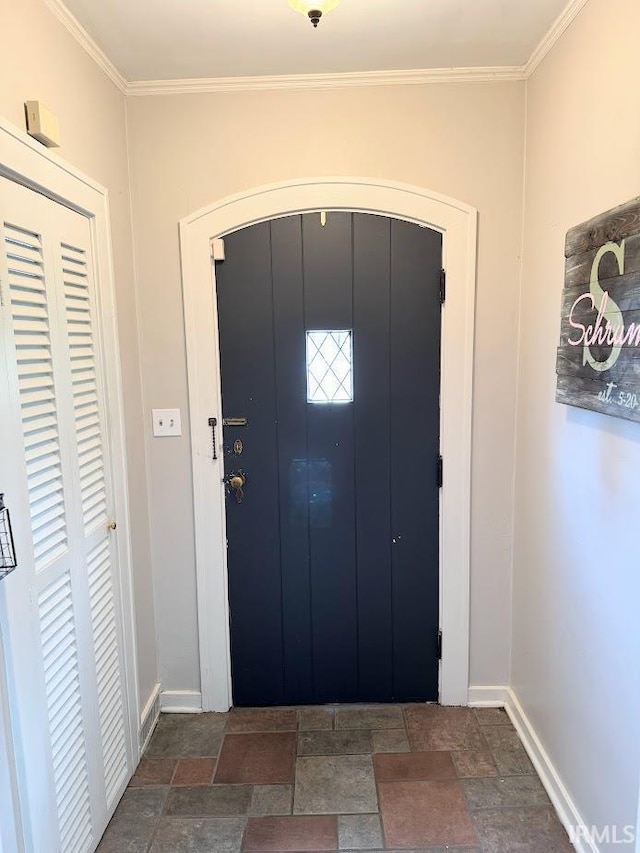 foyer entrance featuring baseboards, stone tile flooring, and ornamental molding