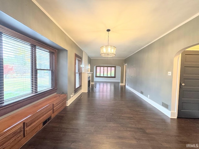 interior space featuring arched walkways, visible vents, dark wood-style flooring, and a chandelier