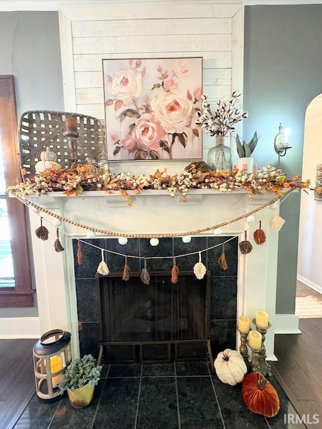 details featuring wood finished floors, arched walkways, and baseboards