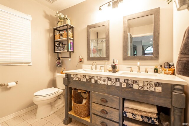 bathroom featuring tile patterned floors, dual bowl vanity, and toilet