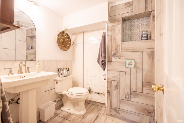 bathroom featuring toilet, decorative backsplash, tile patterned flooring, and tile walls