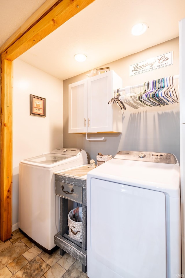 laundry room featuring light tile patterned floors, separate washer and dryer, and cabinets