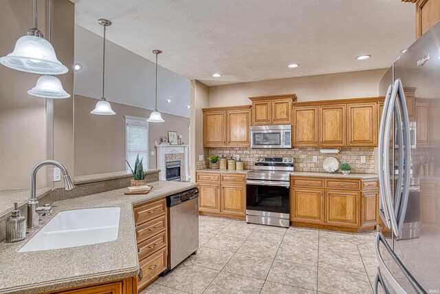 kitchen featuring tasteful backsplash, hanging light fixtures, light tile patterned floors, sink, and stainless steel appliances