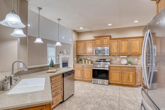 kitchen with decorative light fixtures, sink, tasteful backsplash, a textured ceiling, and appliances with stainless steel finishes