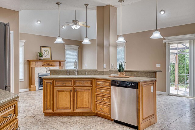 kitchen featuring light tile patterned floors, sink, stainless steel appliances, and a tiled fireplace