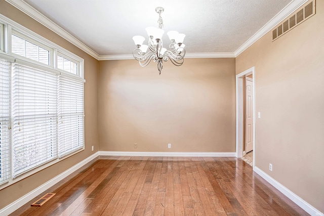 unfurnished room with a notable chandelier, crown molding, wood-type flooring, and a textured ceiling