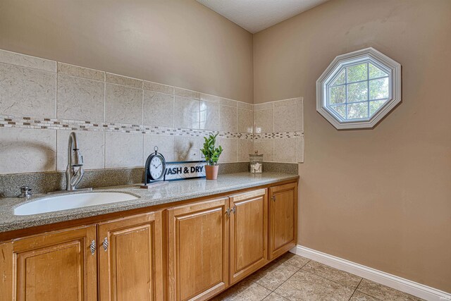 bathroom with tasteful backsplash, tile patterned floors, and vanity