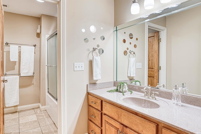 bathroom with tile patterned floors, vanity, and enclosed tub / shower combo