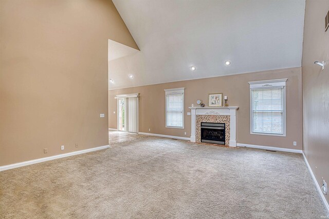 unfurnished living room featuring a fireplace, high vaulted ceiling, and carpet