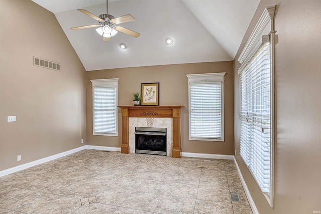 unfurnished living room with ceiling fan, high vaulted ceiling, a tile fireplace, and light tile patterned floors