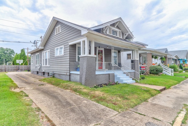 bungalow with a front yard and covered porch