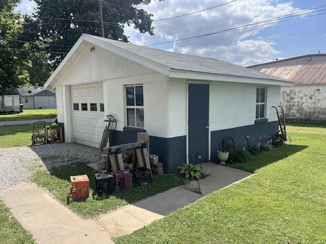 1112 E Fourth St, Mount Vernon, IN 47620 - view of home's exterior with a garage, a lawn, concrete block siding, a shingled roof, and gravel driveway