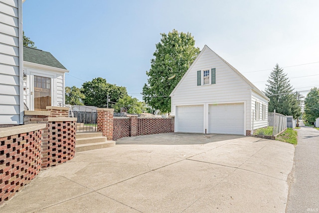 view of home's exterior with a garage and an outbuilding