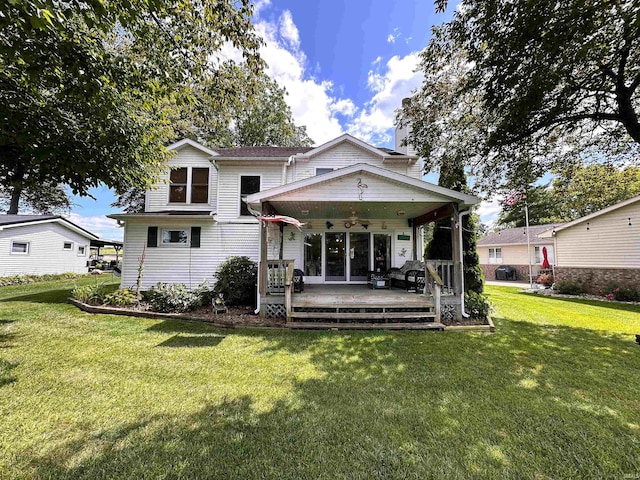 back of house with a lawn, ceiling fan, and a wooden deck