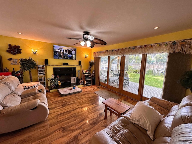 living area featuring a fireplace, wood finished floors, and plenty of natural light