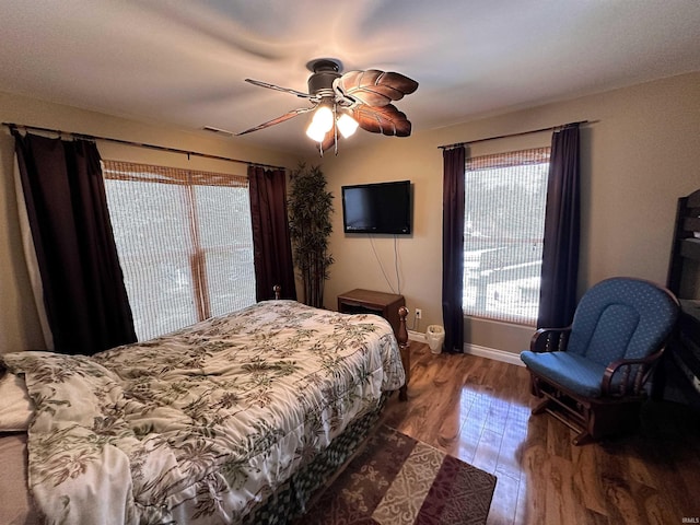 bedroom featuring ceiling fan, baseboards, and dark wood finished floors