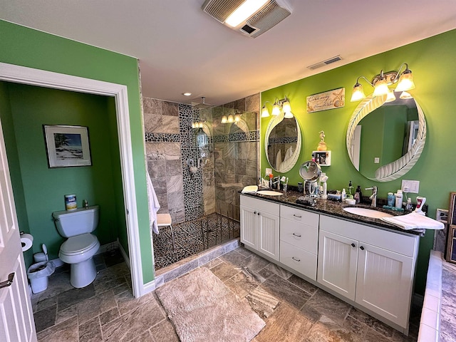 full bath featuring double vanity, a sink, stone tile flooring, and visible vents