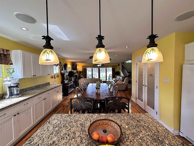 kitchen featuring white fridge, light stone counters, and dark hardwood / wood-style flooring