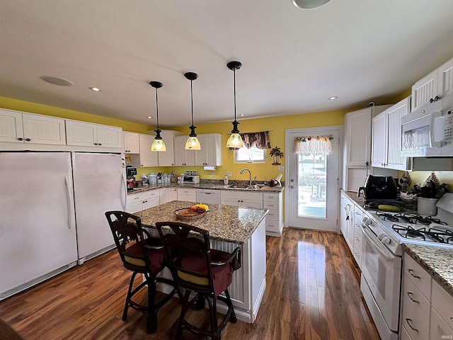 kitchen with white cabinets, white appliances, dark wood-type flooring, and a sink