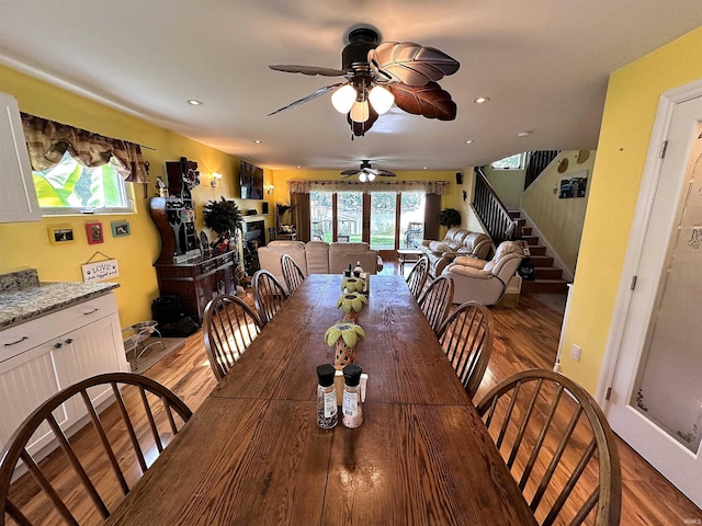 dining room featuring a ceiling fan, light wood-style flooring, recessed lighting, and stairs
