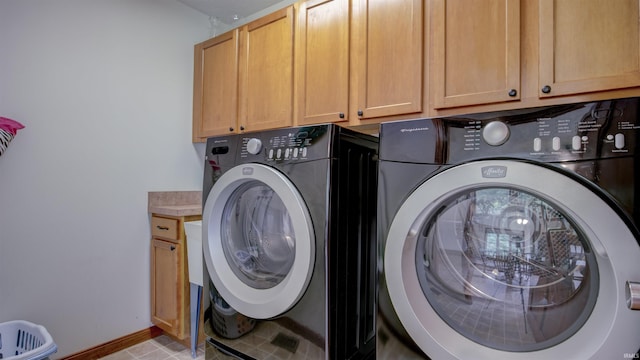 laundry room featuring washer and clothes dryer, cabinet space, and baseboards