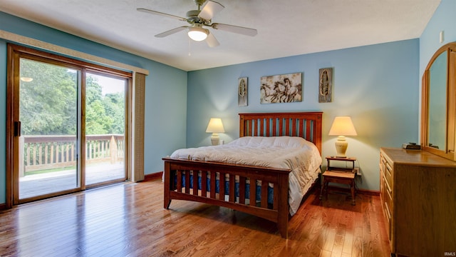 bedroom featuring access to outside, wood finished floors, a ceiling fan, and baseboards