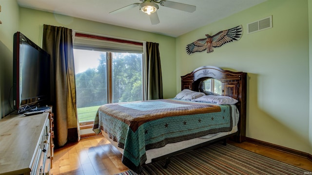 bedroom featuring light wood-type flooring, baseboards, visible vents, and a ceiling fan