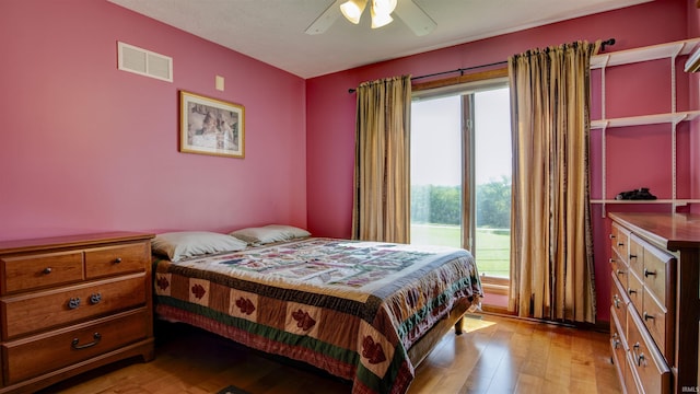 bedroom featuring a ceiling fan, visible vents, and light wood finished floors