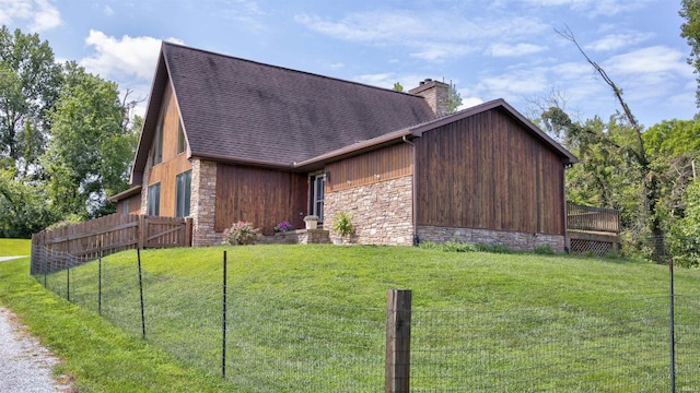 view of front of home featuring a shingled roof, fence, a chimney, and a front lawn