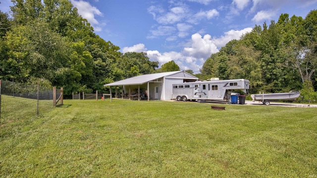 back of property with a lawn and fence