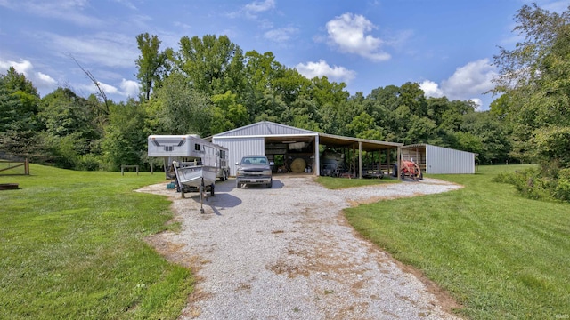 view of yard featuring a pole building, a carport, gravel driveway, and an outdoor structure