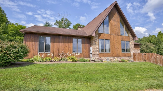 back of house featuring a lawn and fence