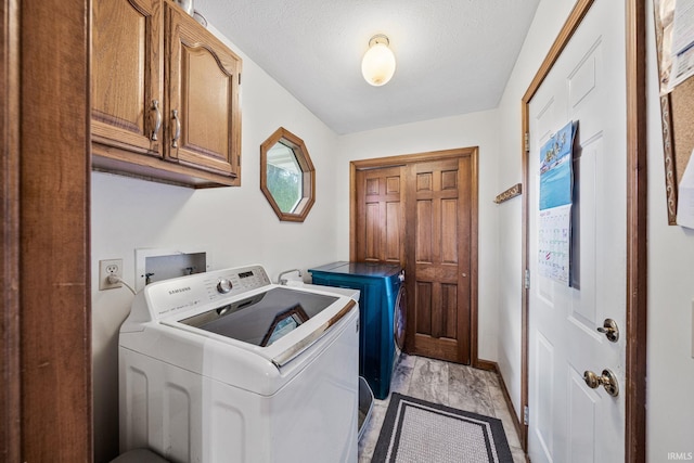 laundry area featuring light hardwood / wood-style flooring, cabinets, and separate washer and dryer