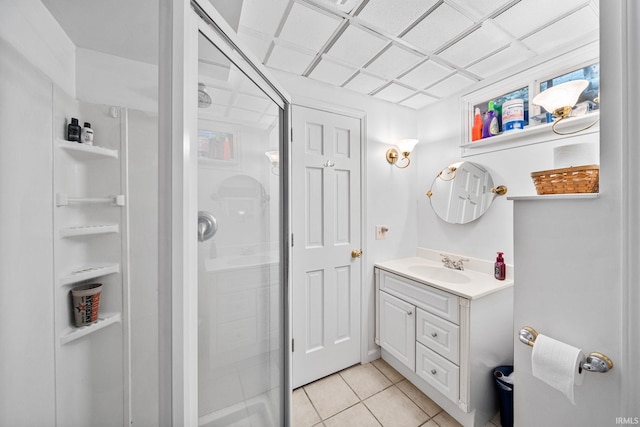 bathroom featuring a shower with shower door, vanity, and tile patterned floors