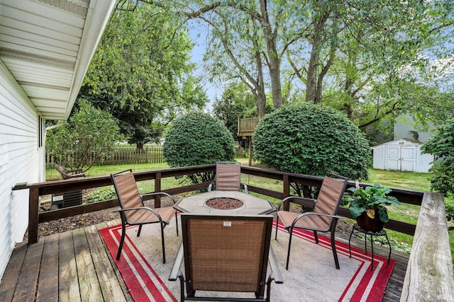 wooden deck with a yard, a shed, and a fire pit