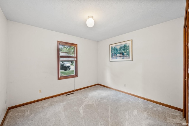 carpeted spare room featuring a textured ceiling