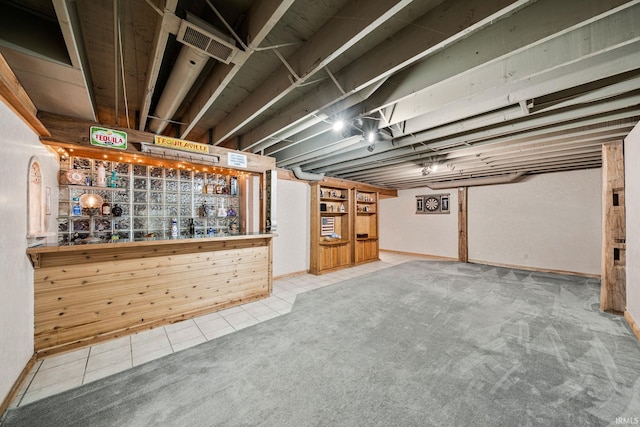 basement with bar area and light colored carpet