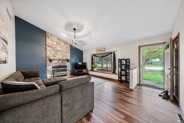 living room featuring ceiling fan, vaulted ceiling, dark hardwood / wood-style flooring, and a fireplace