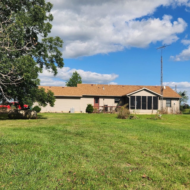 rear view of property with a sunroom and a yard