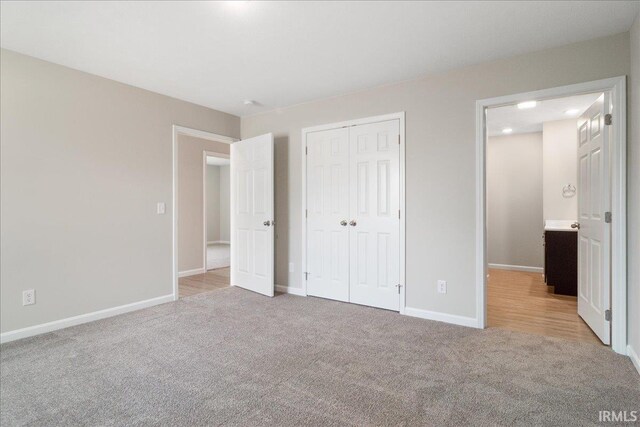 unfurnished bedroom with a closet, carpet flooring, and baseboards