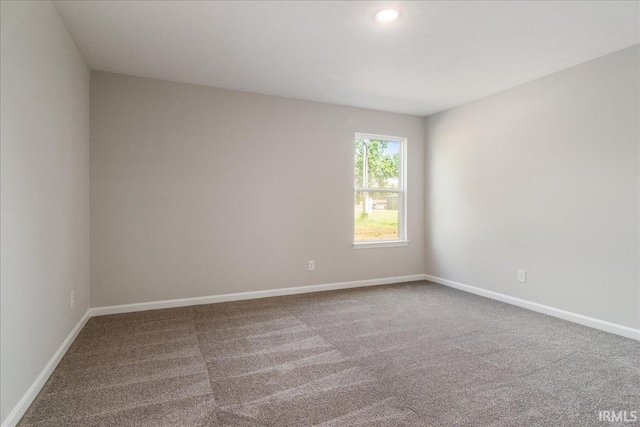 spare room featuring carpet and baseboards