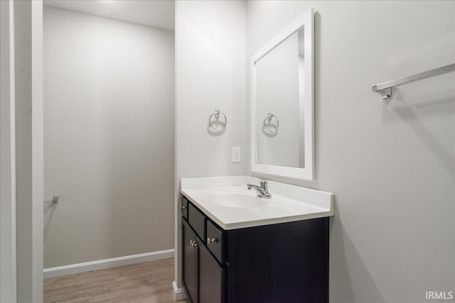 bathroom featuring vanity, baseboards, and wood finished floors