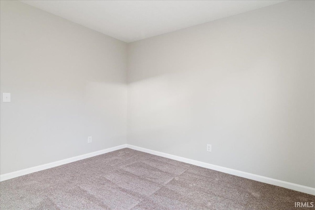 unfurnished room with carpet and baseboards